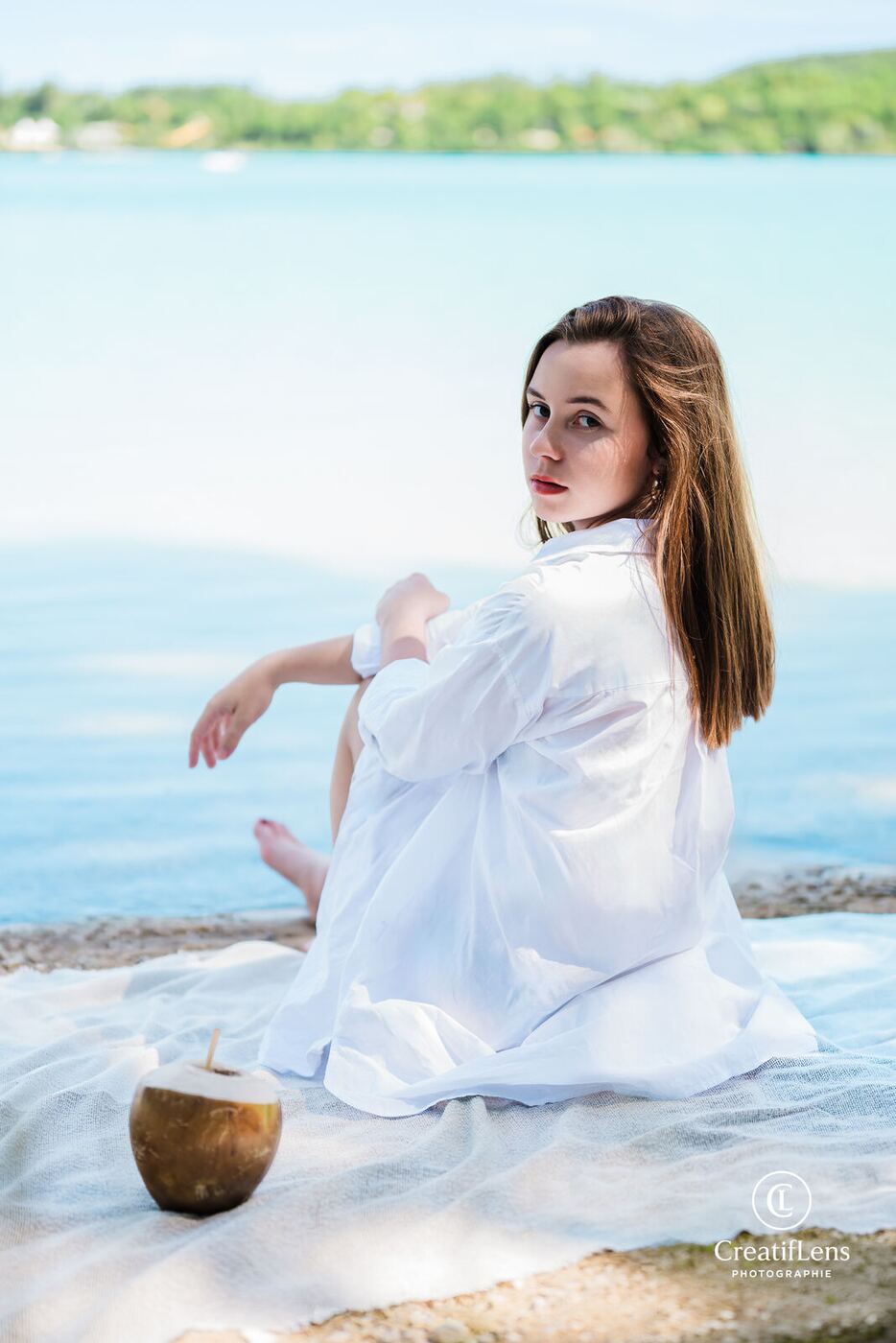 Portrait d'une jeune femme en chemise blanche au bord du lac